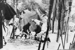 Historic photo from an army postal service outside of a tent.